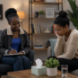 Professional counselling session showing a Pragma Counsellors therapist listening attentively to a distressed woman in her late 20s in a warm, private therapy room focused on emotional abuse recovery and emotional support.